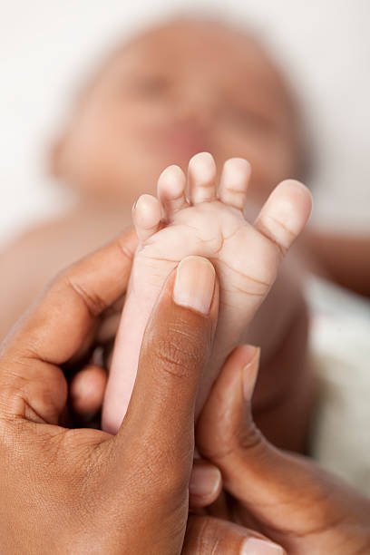 Close up of mother hands massaging baby foot.